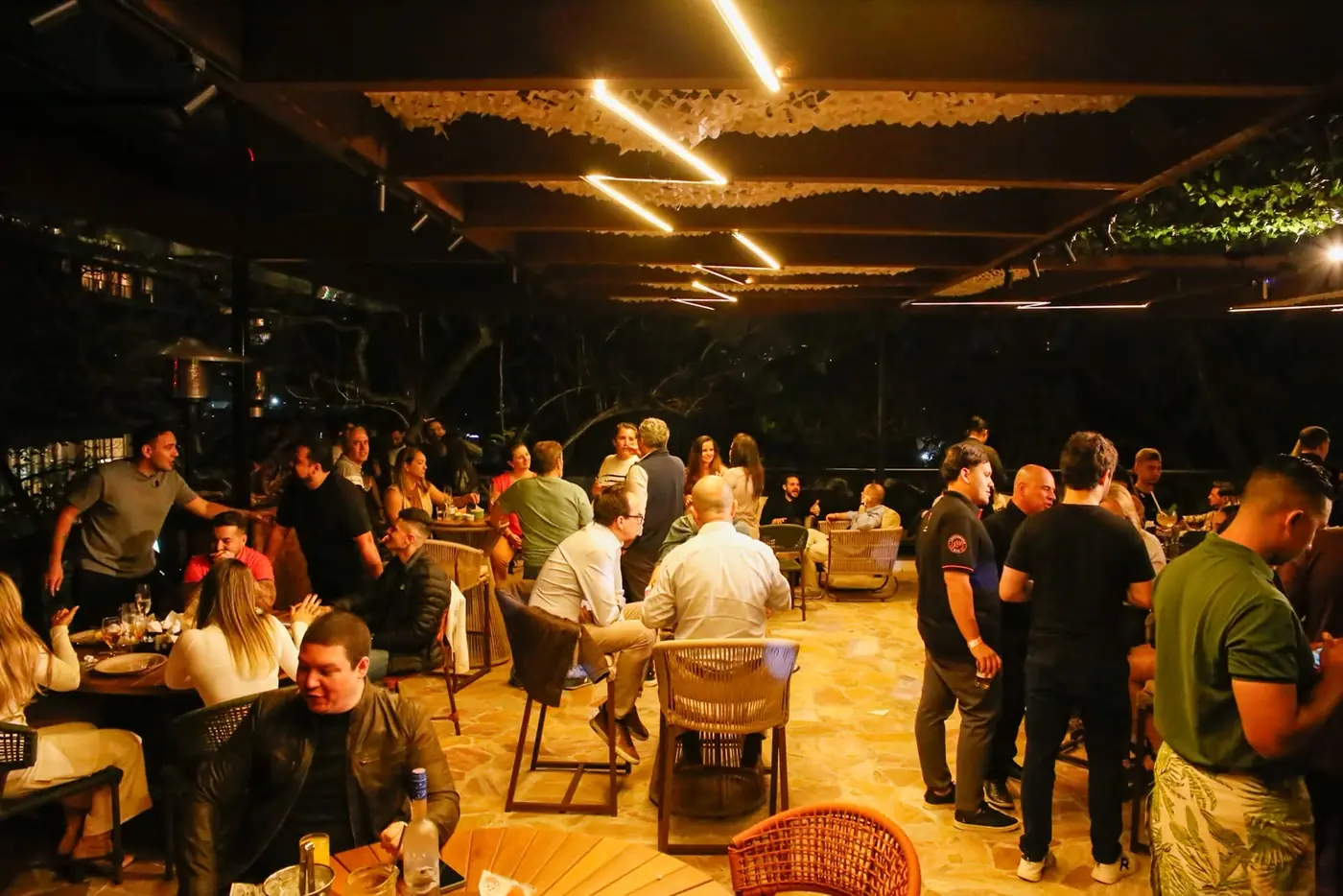 Rooftop do Perobah Pinheiros cheio de convidados durante um evento.