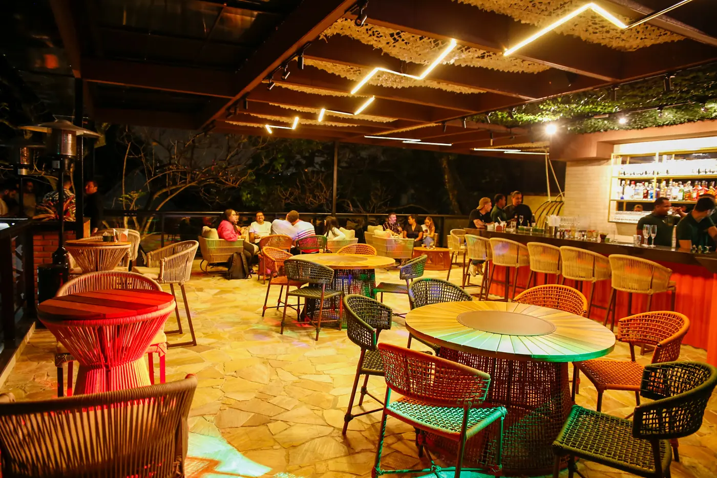 Rooftop do 3º andar do Perobah Pinheiros, mesas e bar, espaço mais vazio.